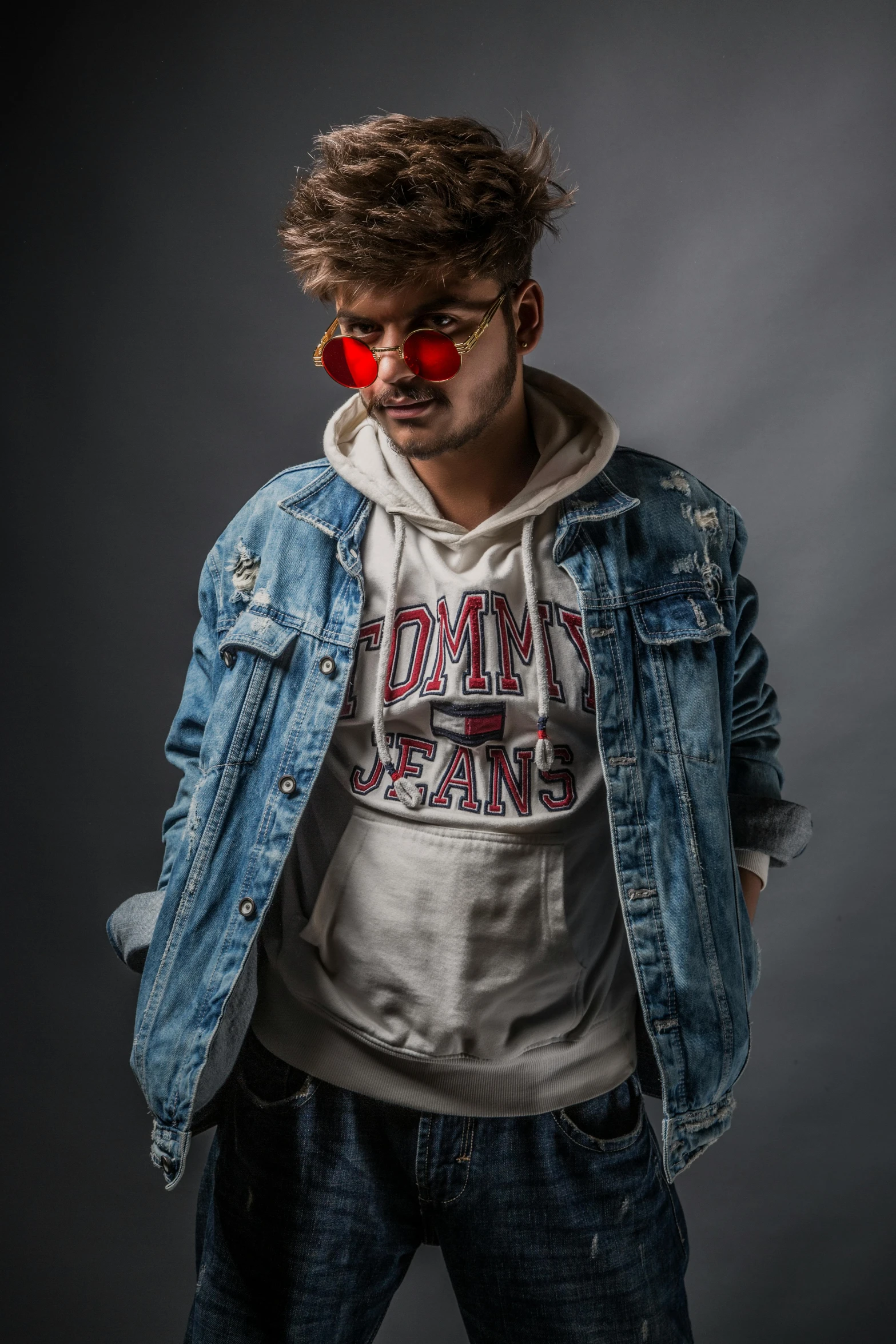 young adult male posing with a denim jacket over his shoulders