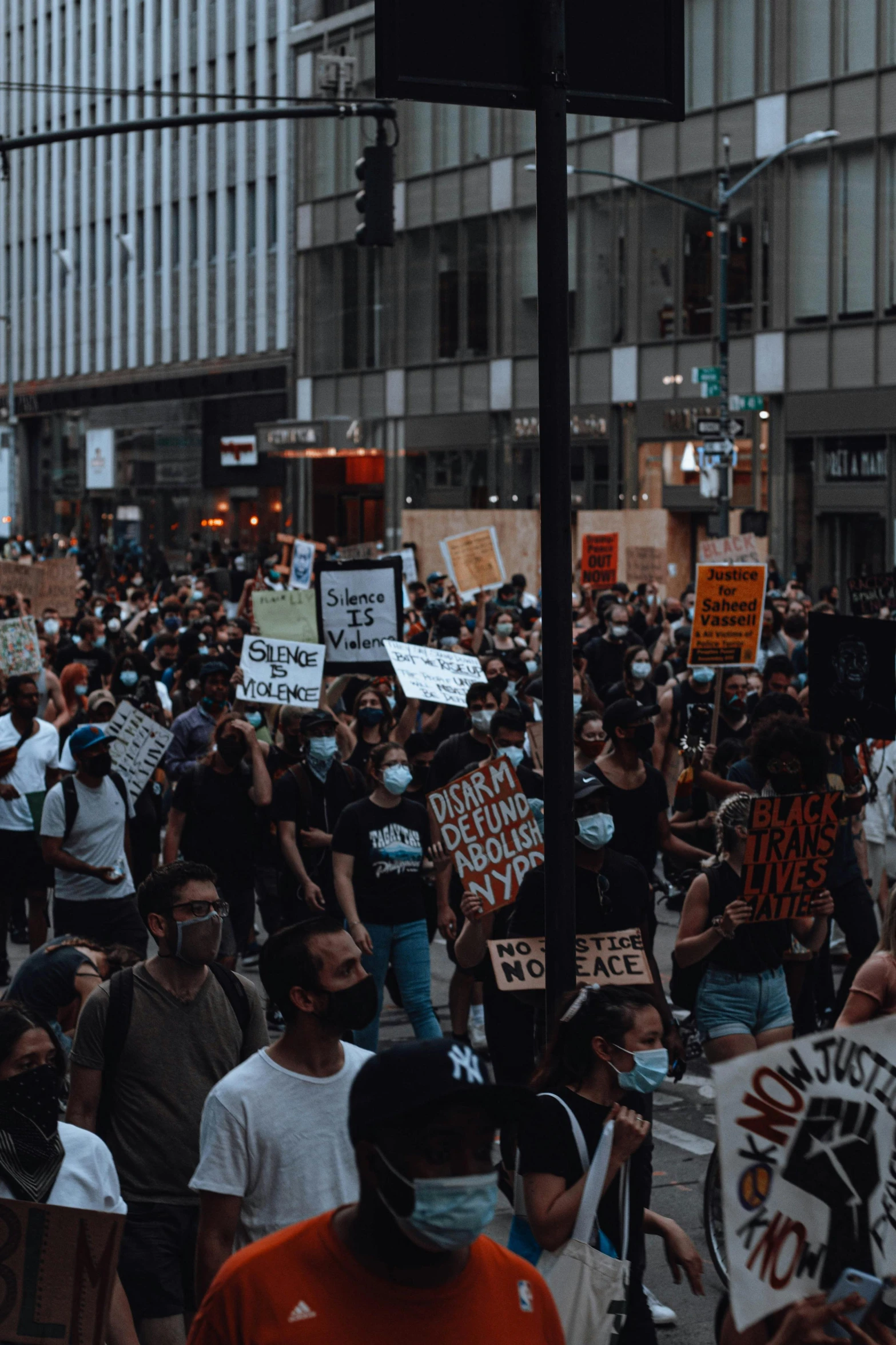 people are marching on a crowded street holding signs