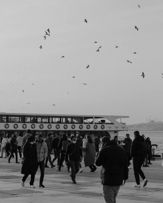 a bunch of people are walking around in front of some water