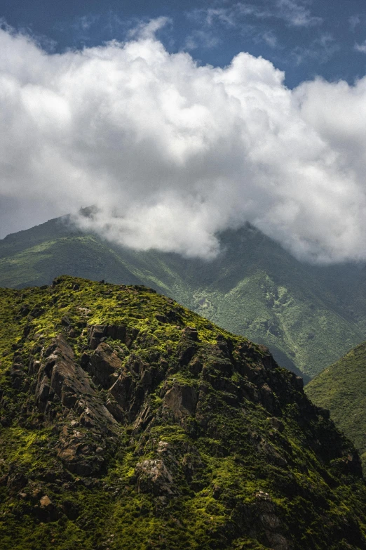 the top of a large rocky hill covered in green vegetation