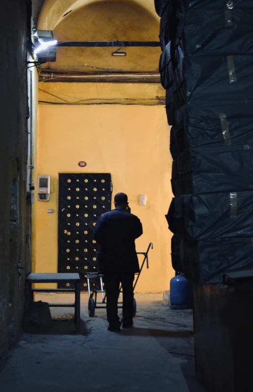 a man is standing in an alleyway in a dark place