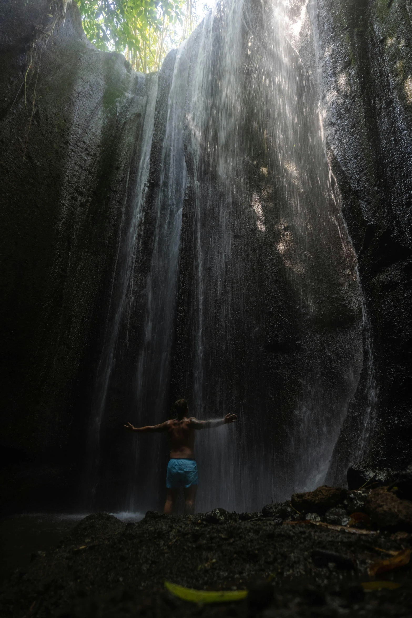 there is an image of a person underneath the waterfall