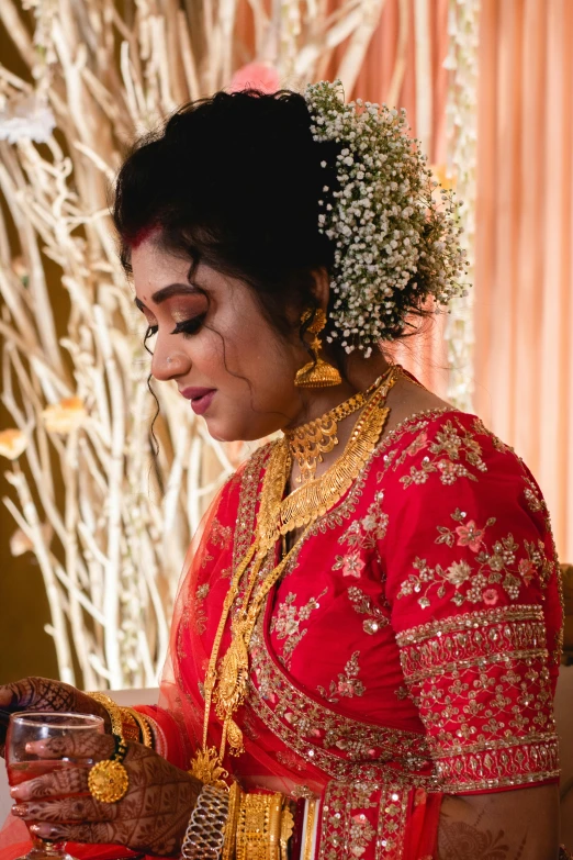 a woman dressed in a red outfit putting on jewelry