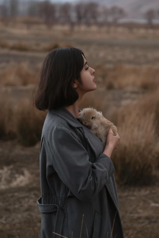 a woman with a cat in her arms standing outside