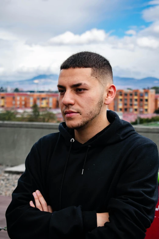 young male staring intently at the camera with his arms crossed