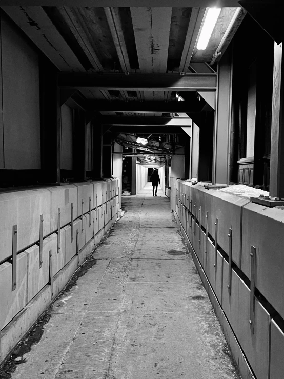 a man is walking down an empty hallway