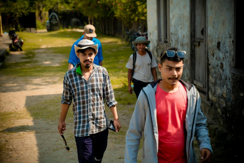 group of men with old looking clothing and walking down a road