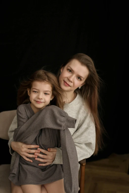 the woman is holding her daughter next to the chair