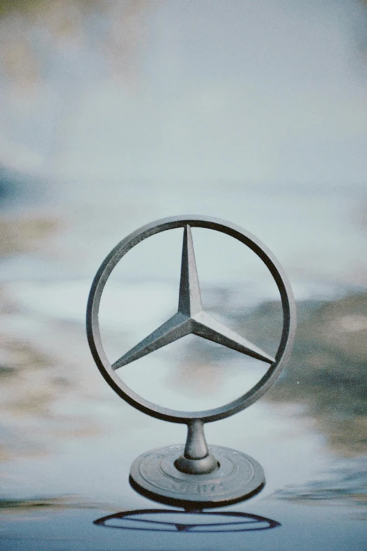 the emblem of a mercedes vehicle on a glass top