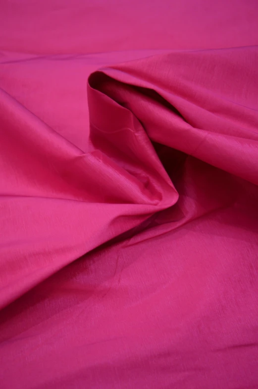 closeup view of the pink silk fabric from the bed