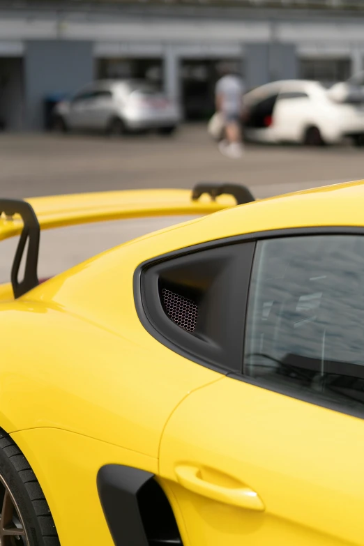 the reflection in the side view mirror of a yellow car