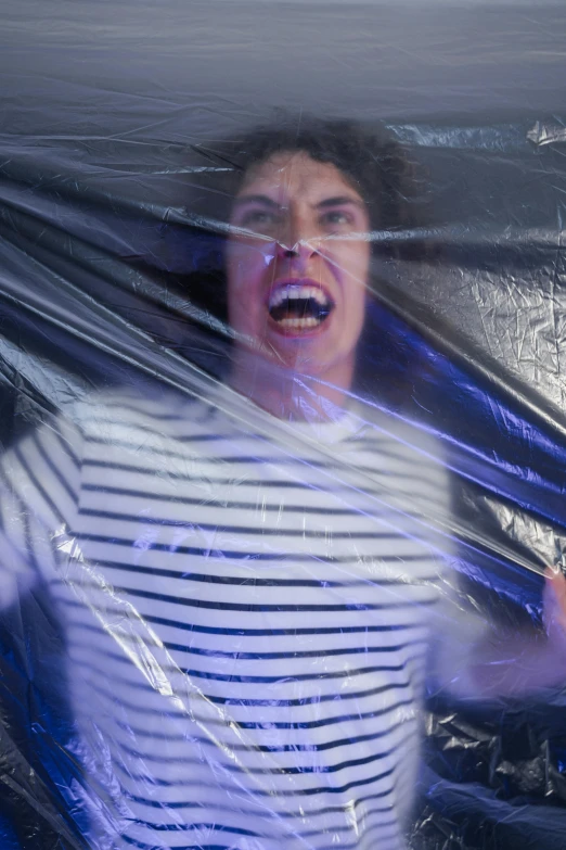 a woman standing behind plastic bag holding soing