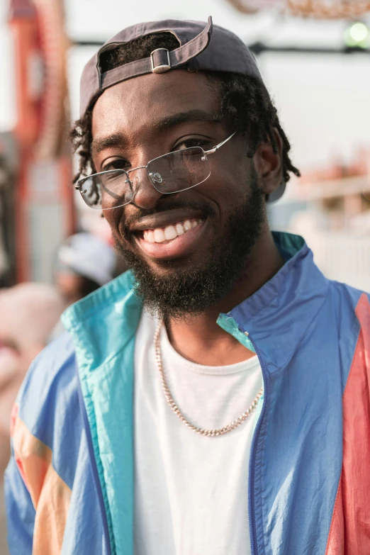 a man with glasses smiling while wearing a shirt