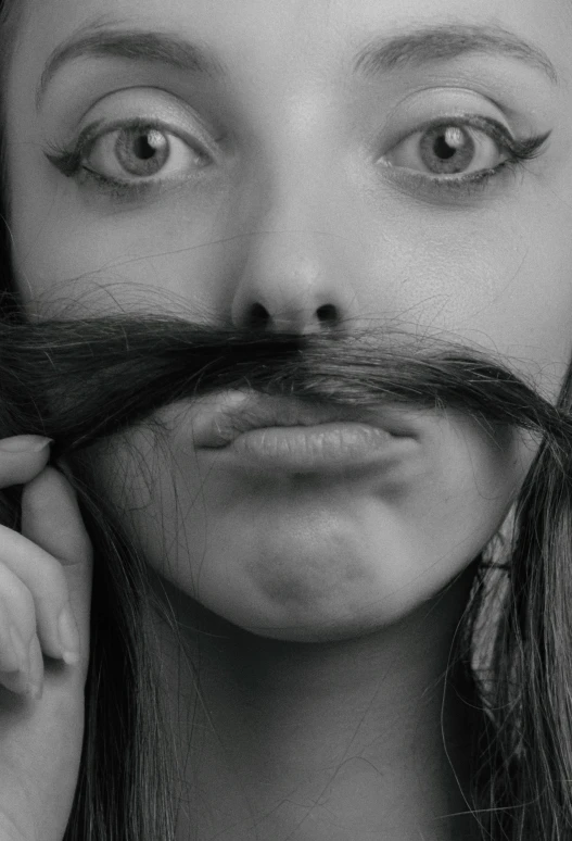 a woman with a long moustache holding her hand to her face