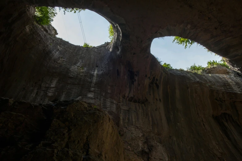 three circular views looking at the sky in a cave