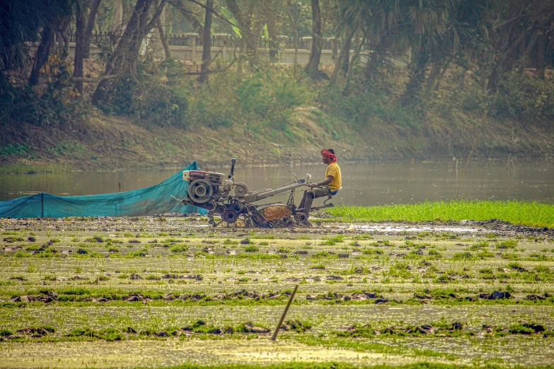 a tractor driving along a muddy field on a rainy day