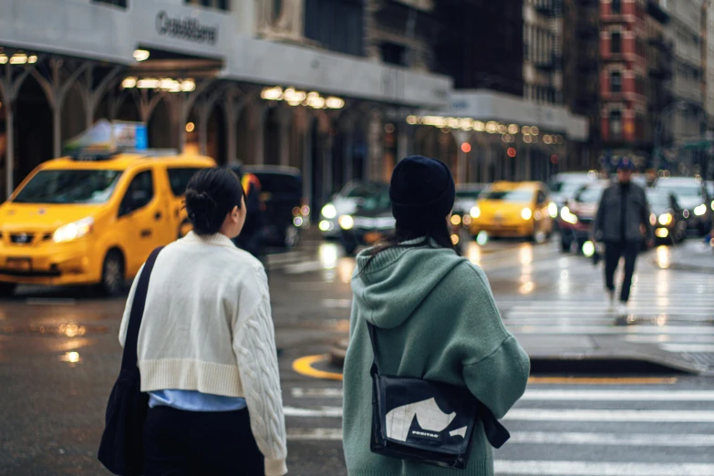 a couple walk across the street as traffic comes in to cross