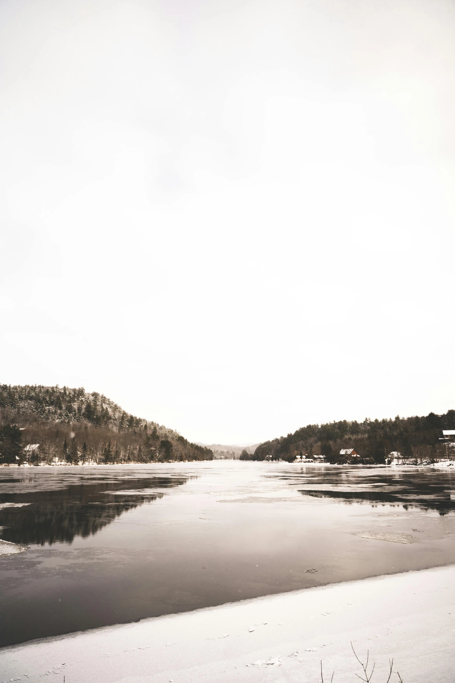 snow covers the ground in front of a lake