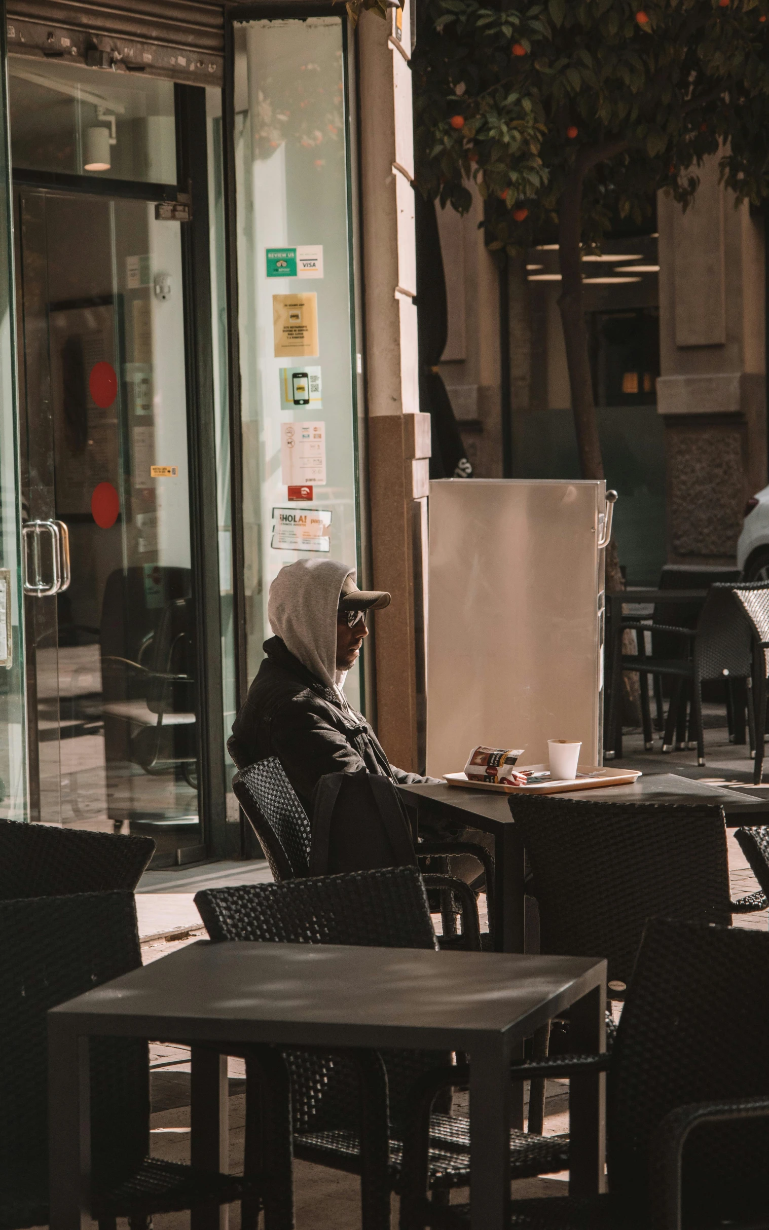 there is a man sitting at a table in a cafe