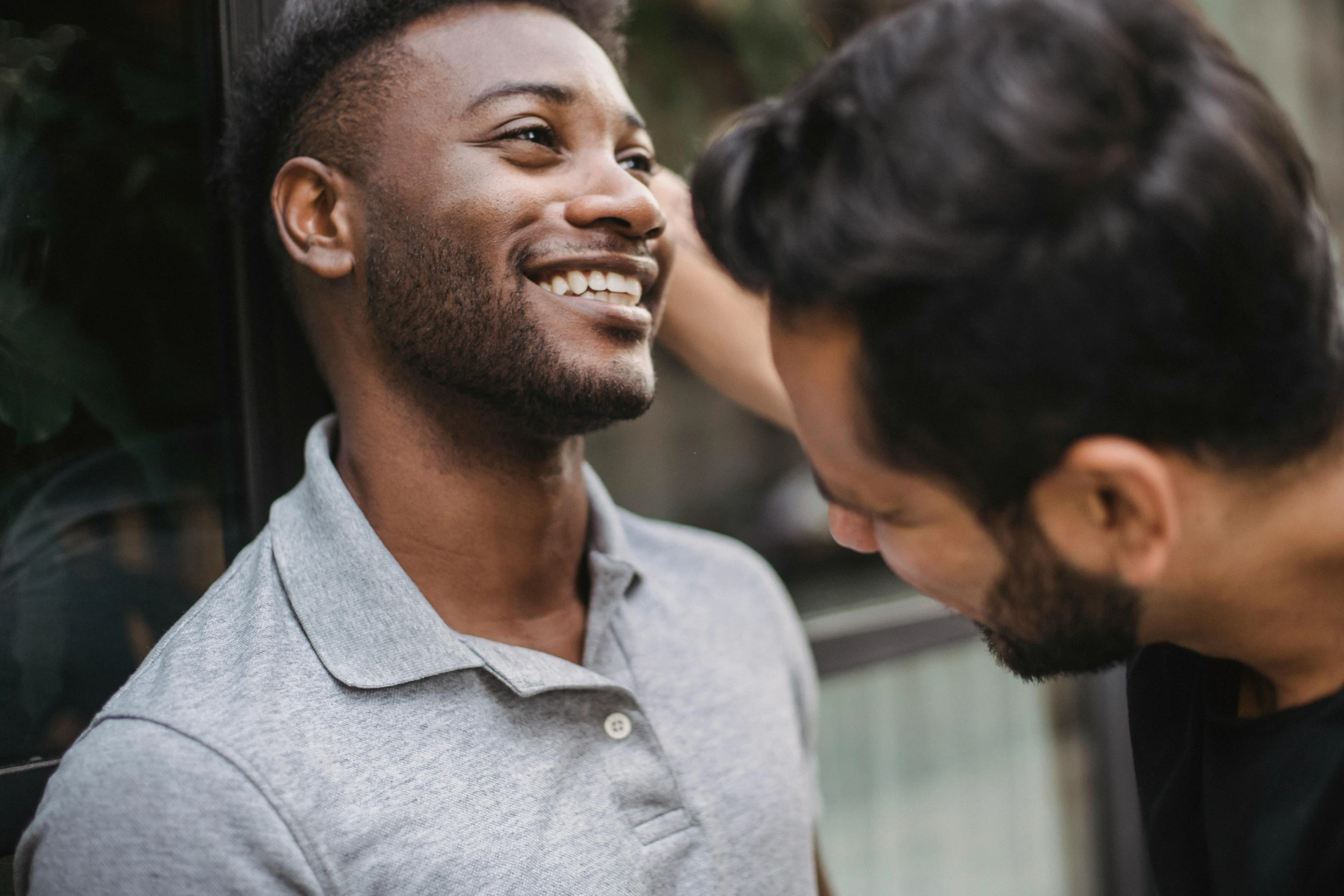 two men standing outside together having fun talking