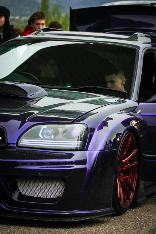 an image of people around a purple car