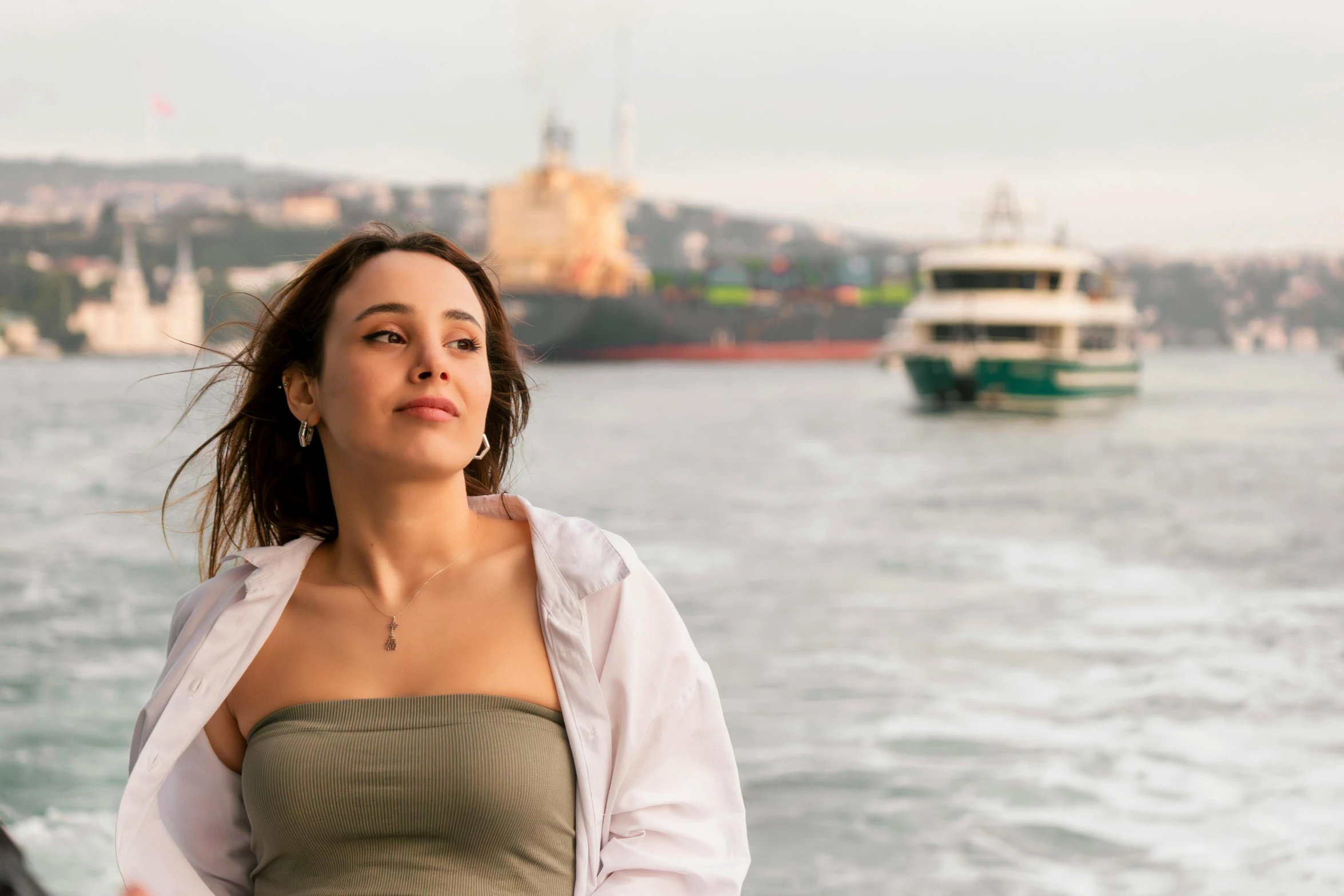 a lady that is looking into the distance next to a body of water