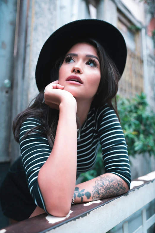 a woman with long hair posing for a po on a ledge