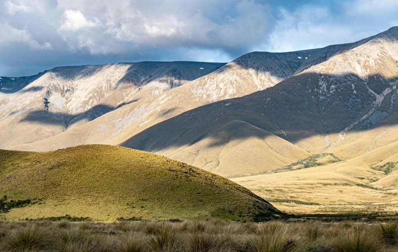 some very pretty hills with snow capped mountains