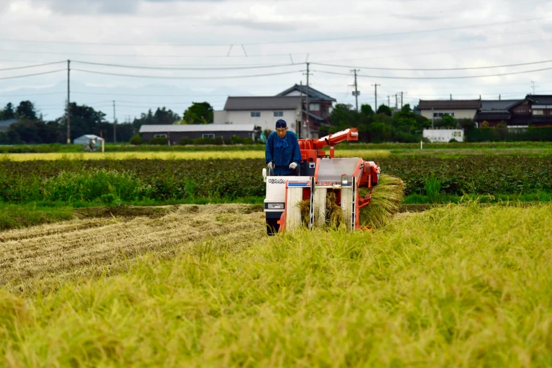 two people ride on a tractor in a field