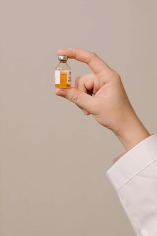 a woman holding a medicine bottle with liquid inside