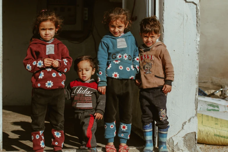 group of small children standing outside on a sunny day