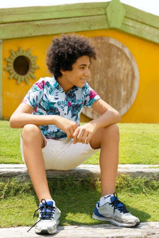 a young man sits on the edge of the grass