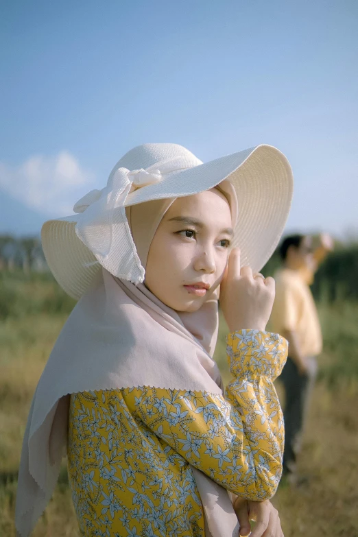 an image of a woman wearing a large hat and scarf