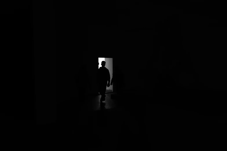 an unknown person looks out from behind a doorway