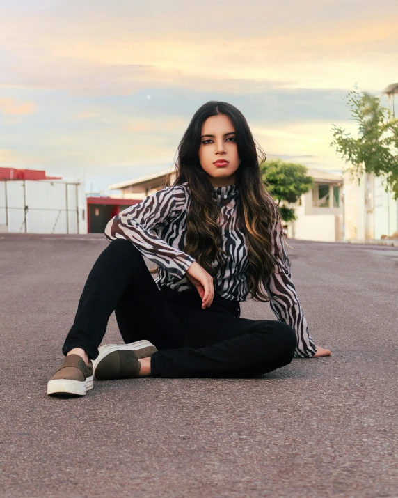 a woman with long hair sitting on the ground