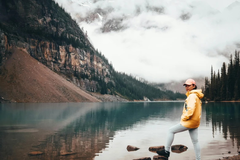 the man is standing on the rocks by the water