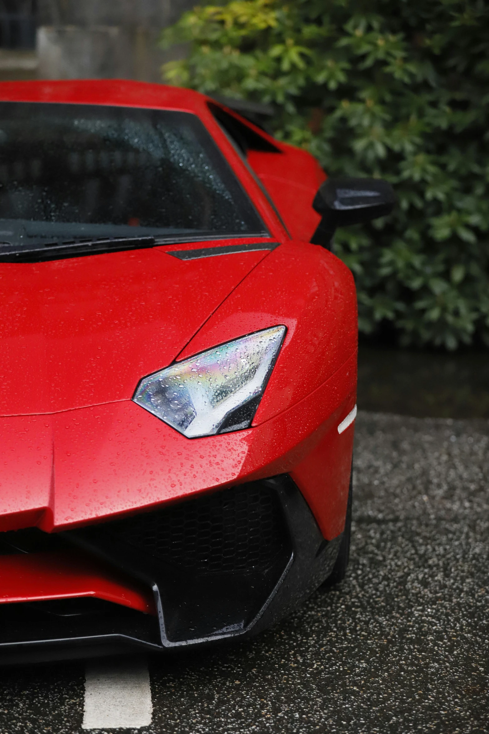 a red car with headlights parked on the street