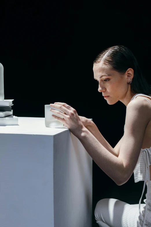 a woman is standing and touching the top of the table