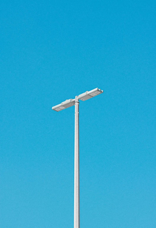 a close up of two street lights against a blue sky