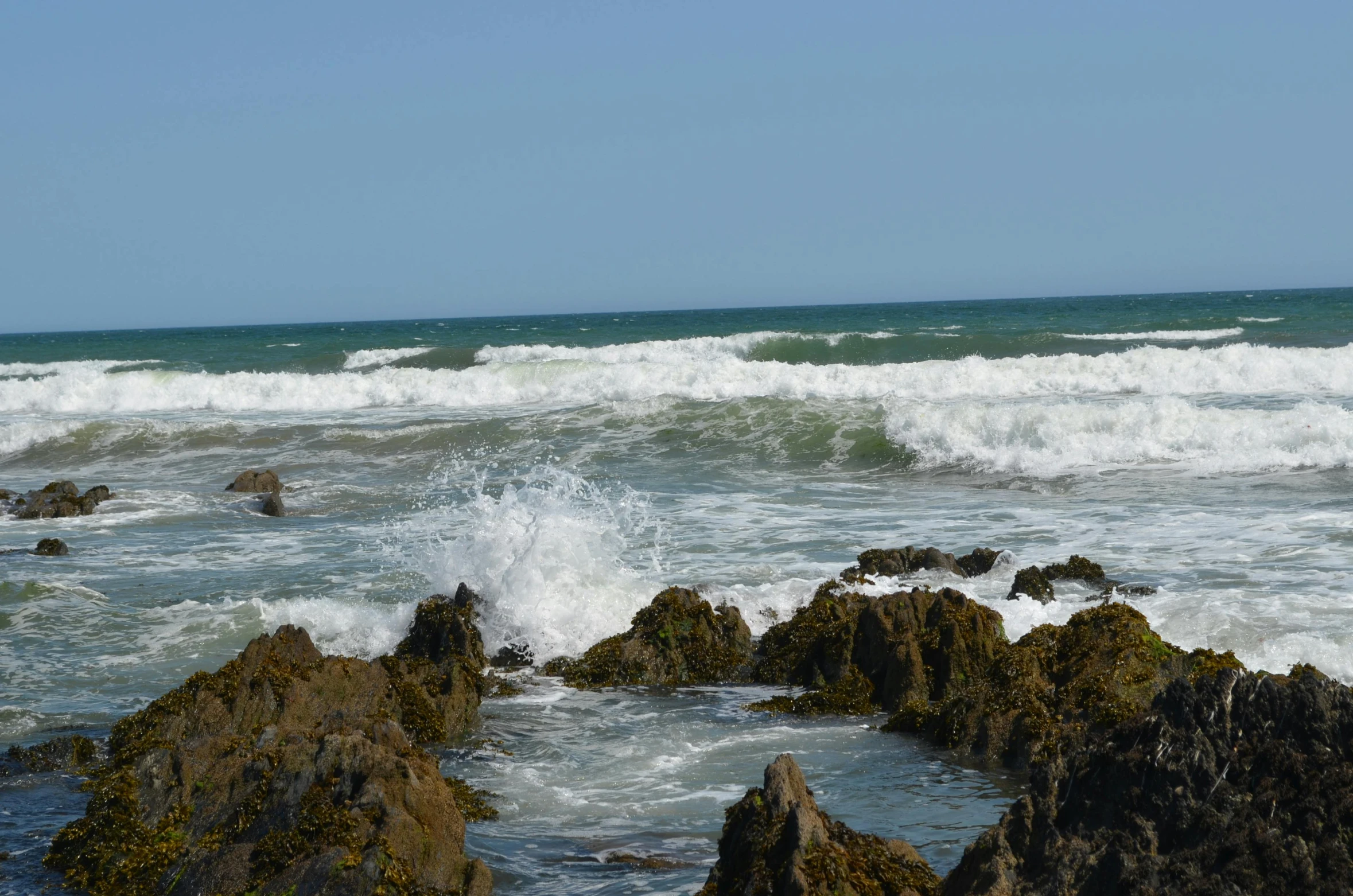 the beach is littered with rocks and large waves