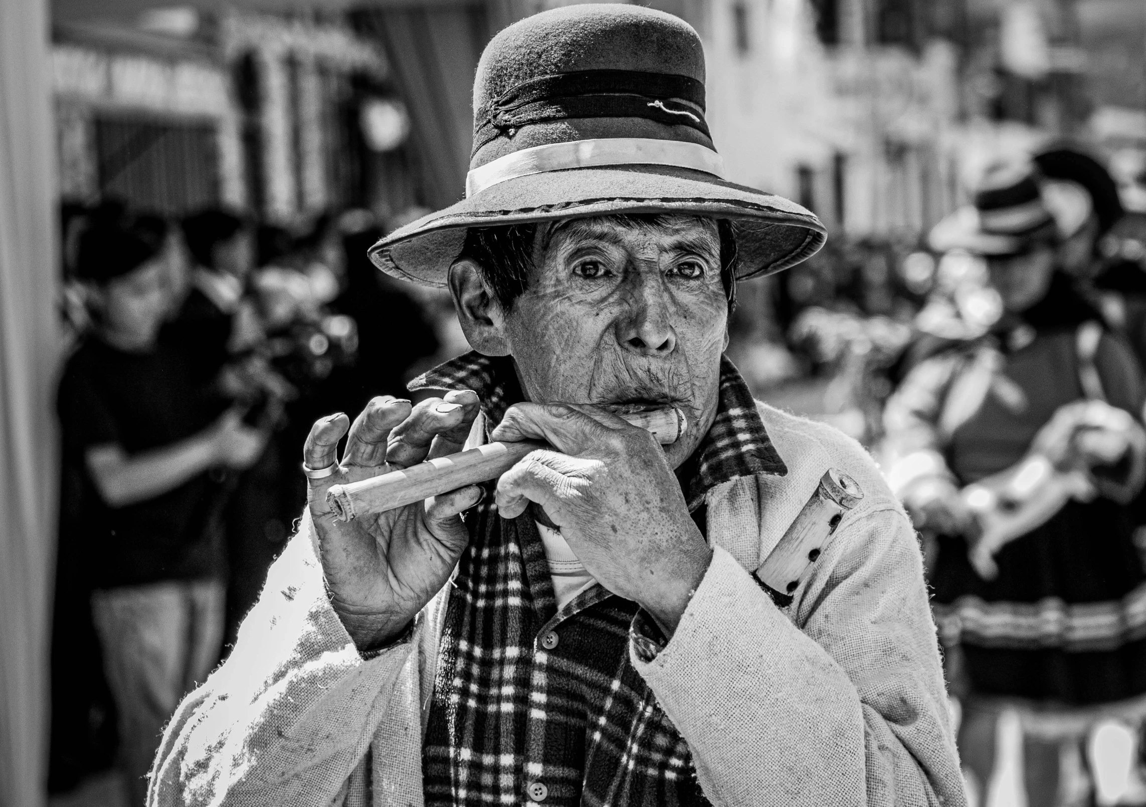 a black and white image of a man in a cowboy hat smoking a cigarette