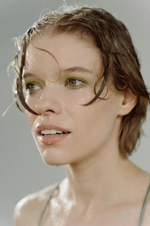 woman in the sunlight taking shower with water on her face