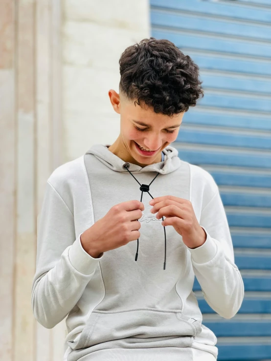 a boy standing outdoors holding soing in his hands