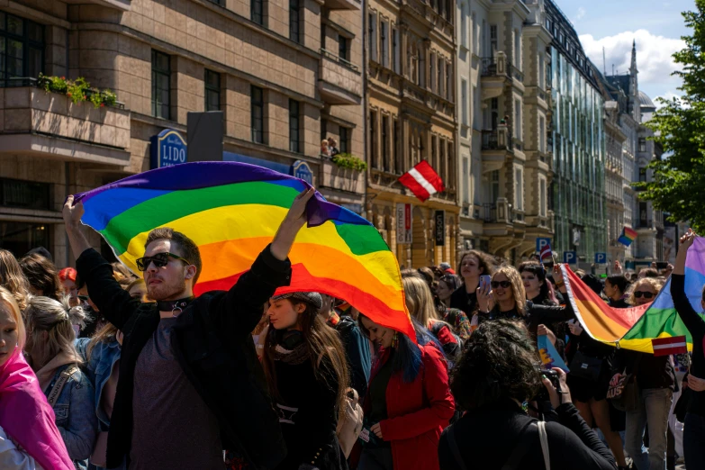 the woman is holding up a rainbow flag