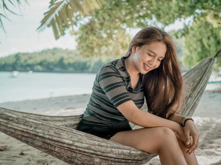 a woman with long hair sitting in a hammock