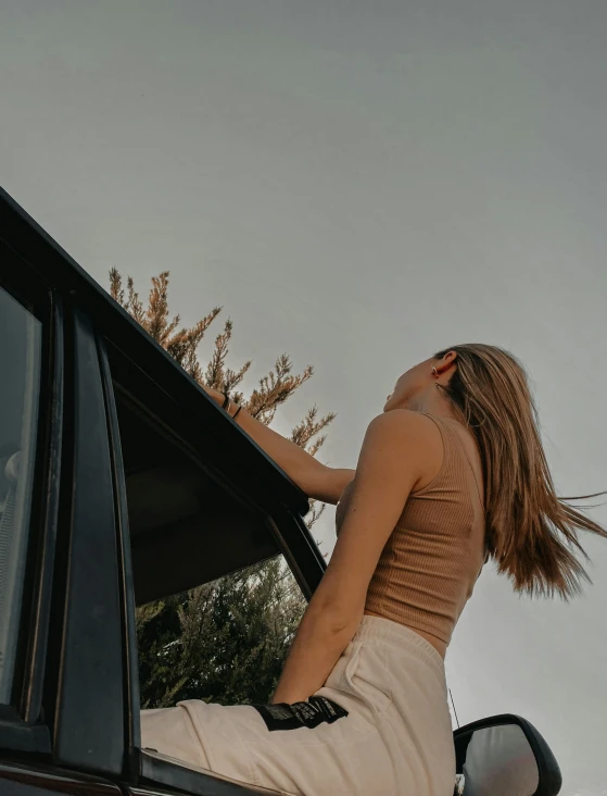 woman leaning out of car window with back window open