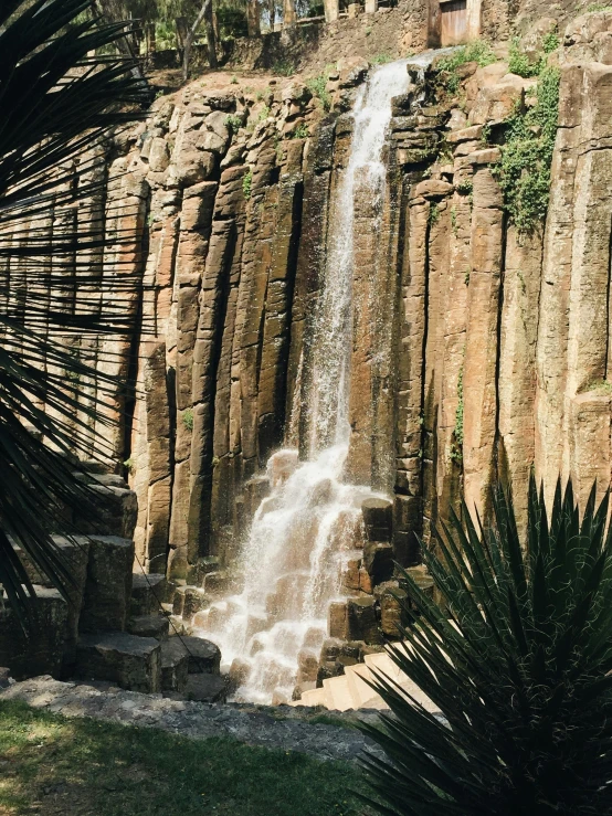 the waterfall is coming down the side of the mountain