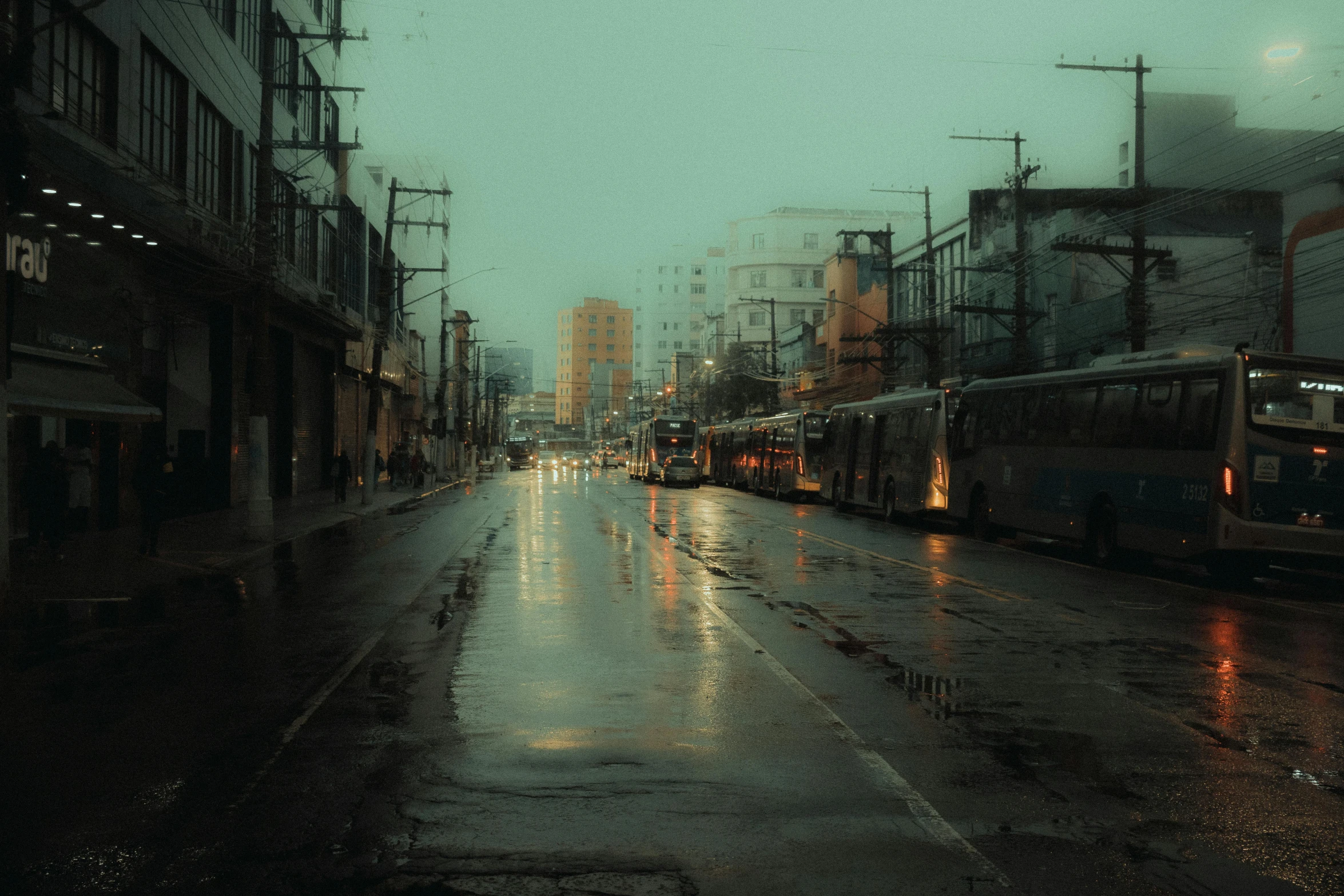 the city street is wet and dark at night