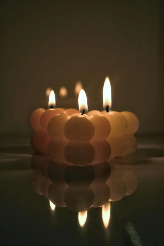 two candles are sitting next to each other in the dark