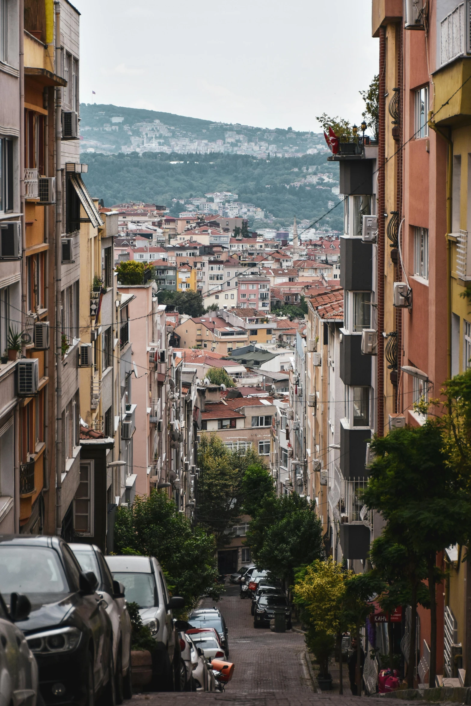 cars parked along a cobble stone road in a city